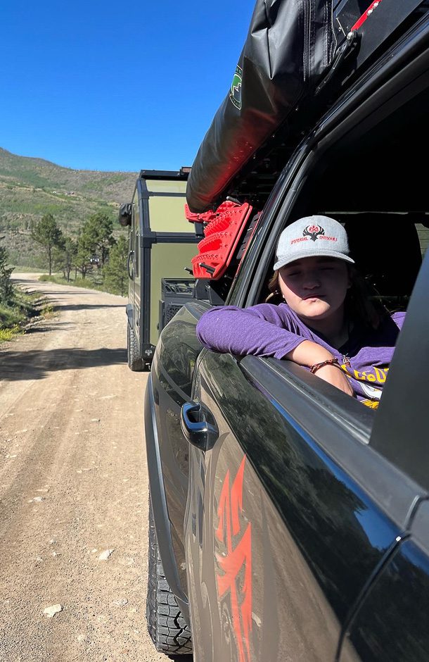 Girl enjoying the drive on a back county road pulling an Imperial Outdoors Xplore Series X195 RV.