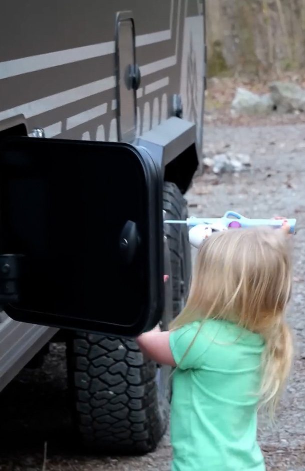Little girl packing away her belongings into an Imperial Outdoors off grid camper.