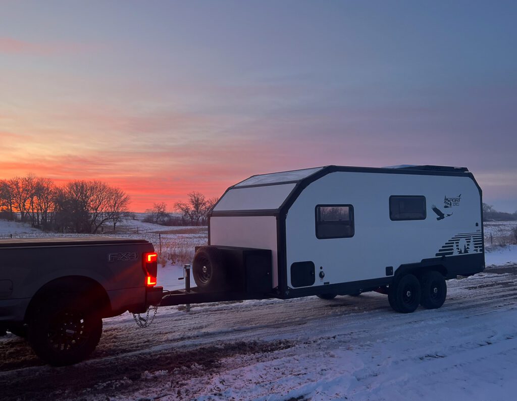 Imperial Outdoors S195 driving down a frozen snowing trail at sunset.