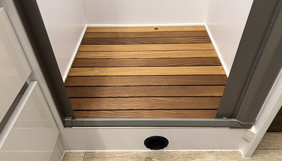 Imperial Outdoors stainless steel shower pan with waterproof teak wood slat insert.