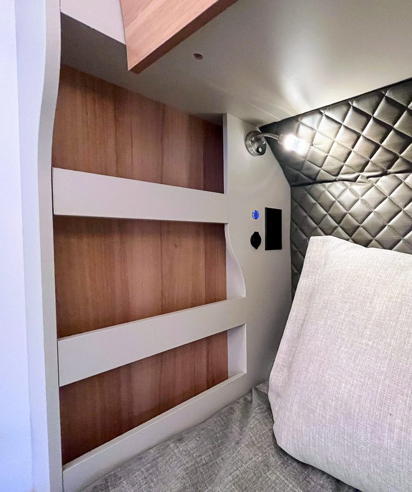Cubby shelving and lighting next to the bed in the S195 from Imperial Outdoors.