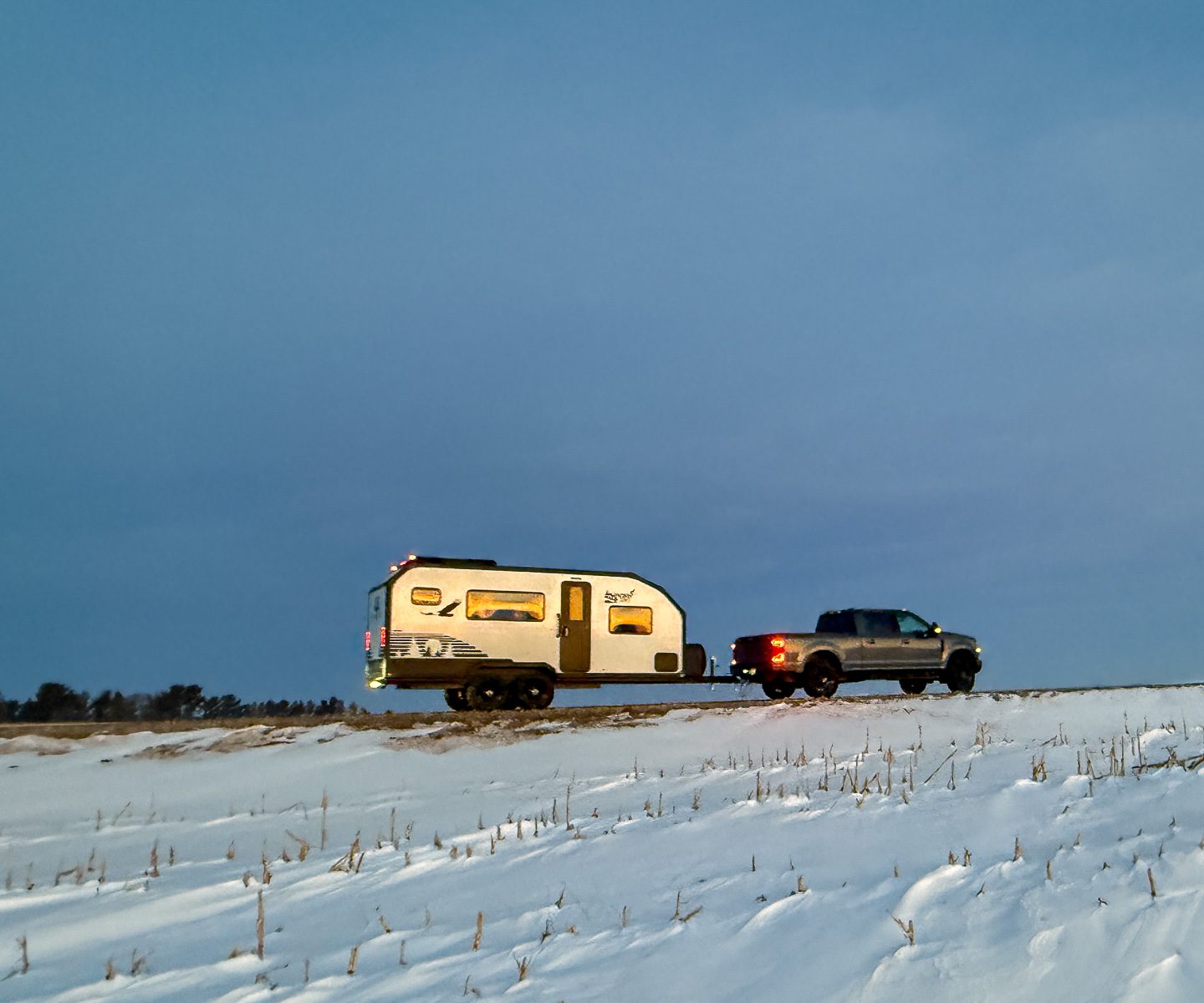 Imperial Outdoors S195 being pulled down a snowy trail in the open plains.