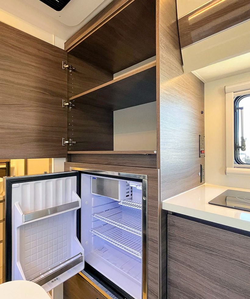 Open cabinet and open fridge in the camper X145 from Imperial Outdoors.