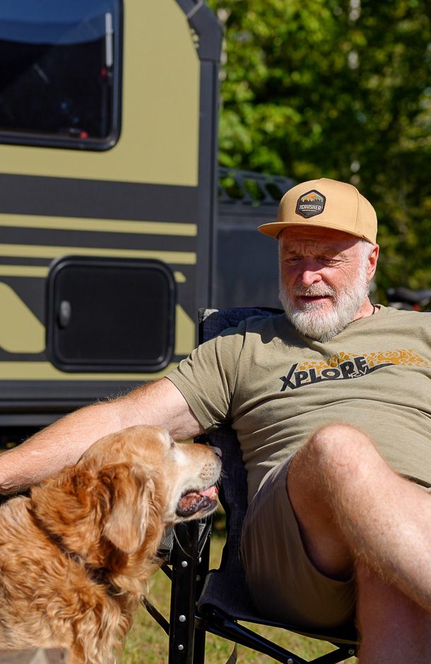 Man and his golden retriever relaxing at base camp with they Imperial Outdoors X145.