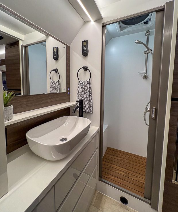 Imperial Outdoors RV Luxurious bathroom with a full stand up shower, and has a teak shower floor.