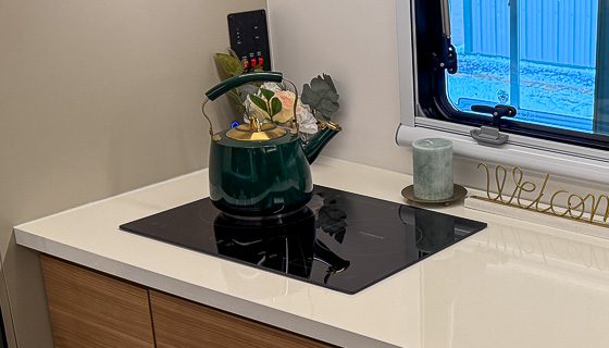Making tea on the dual induction cooktop in the kitchen of the Imperial Outdoors S195.