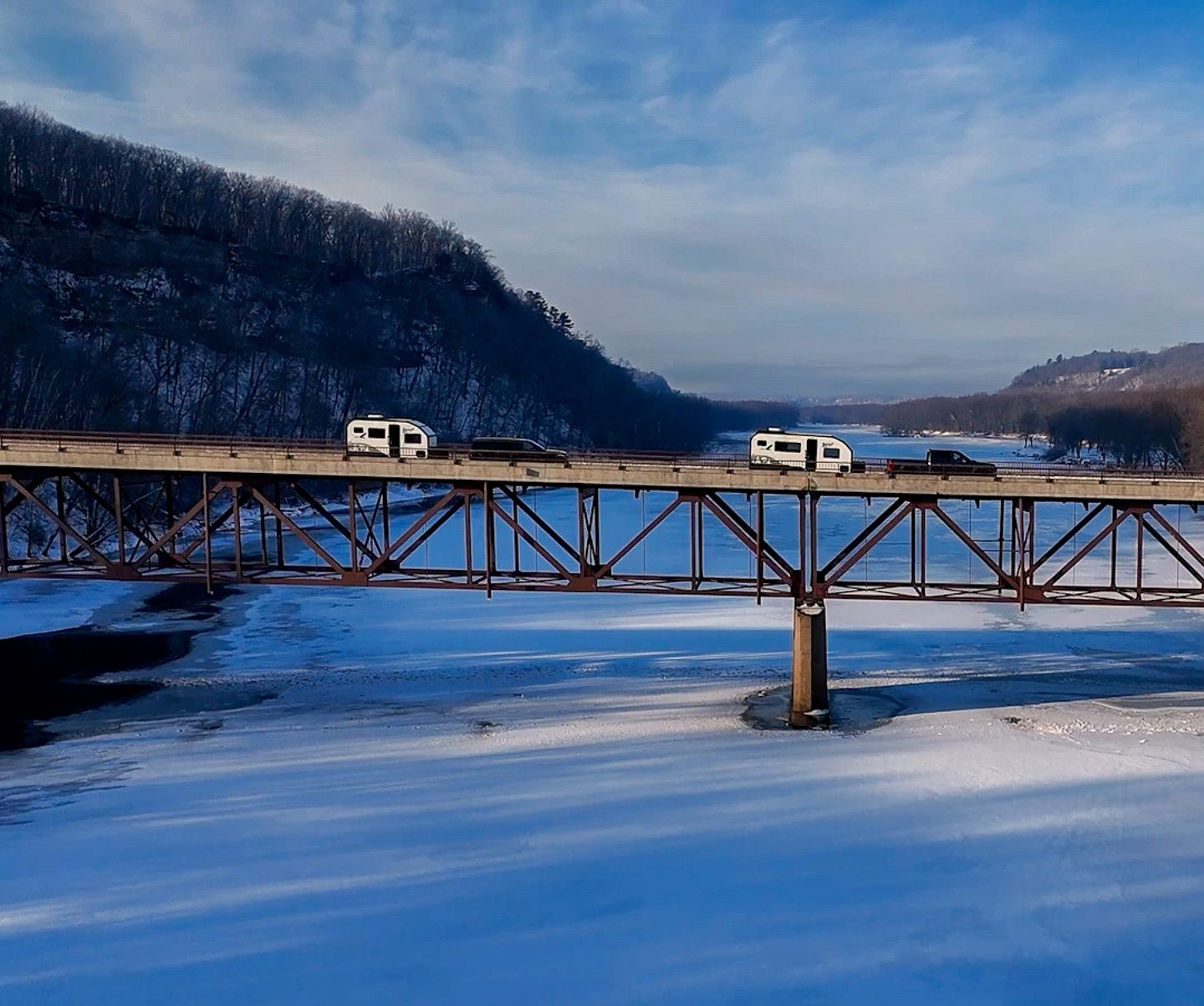 Imperial Outdoors Sport Series S145 and S195 traveling on a bridge over a frozen river.