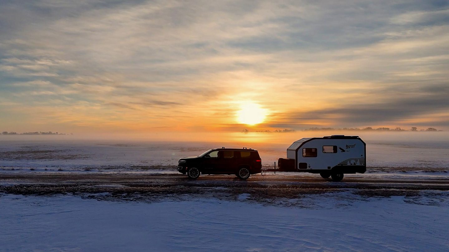 Imperial Outdoors Sport Series S145 being towed by a Jeep Wagoner in a foggy cold winter morning sunrise.