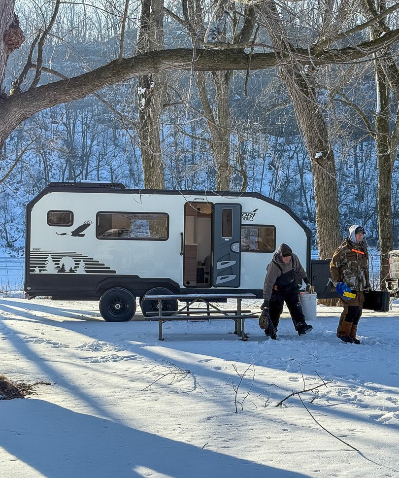Two friends camping along a lake to go ice fishing with their Imperial Outdoor Sport Series S195.