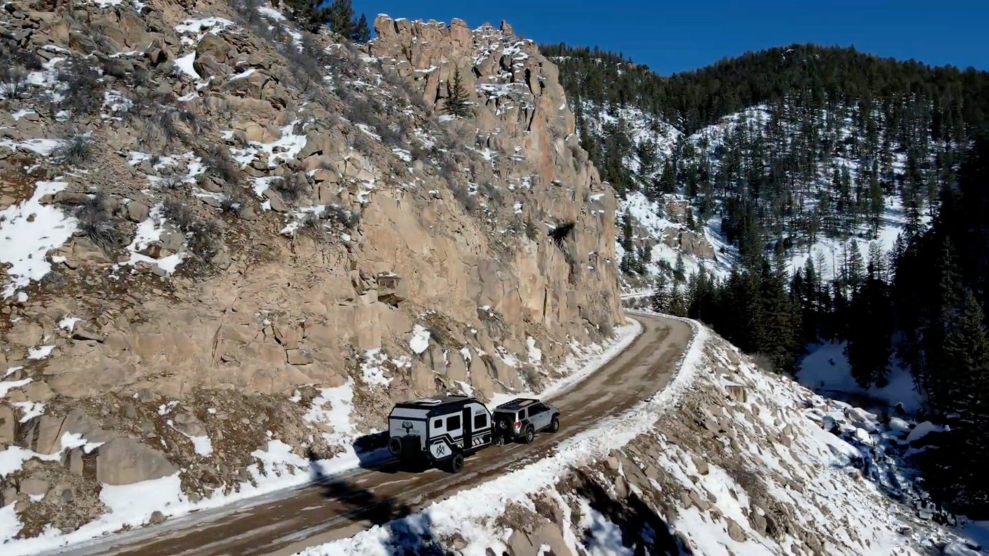 Snowy mountain road with a X145 from Imperial Outdoors being pulled by a Toyota 4Runner.