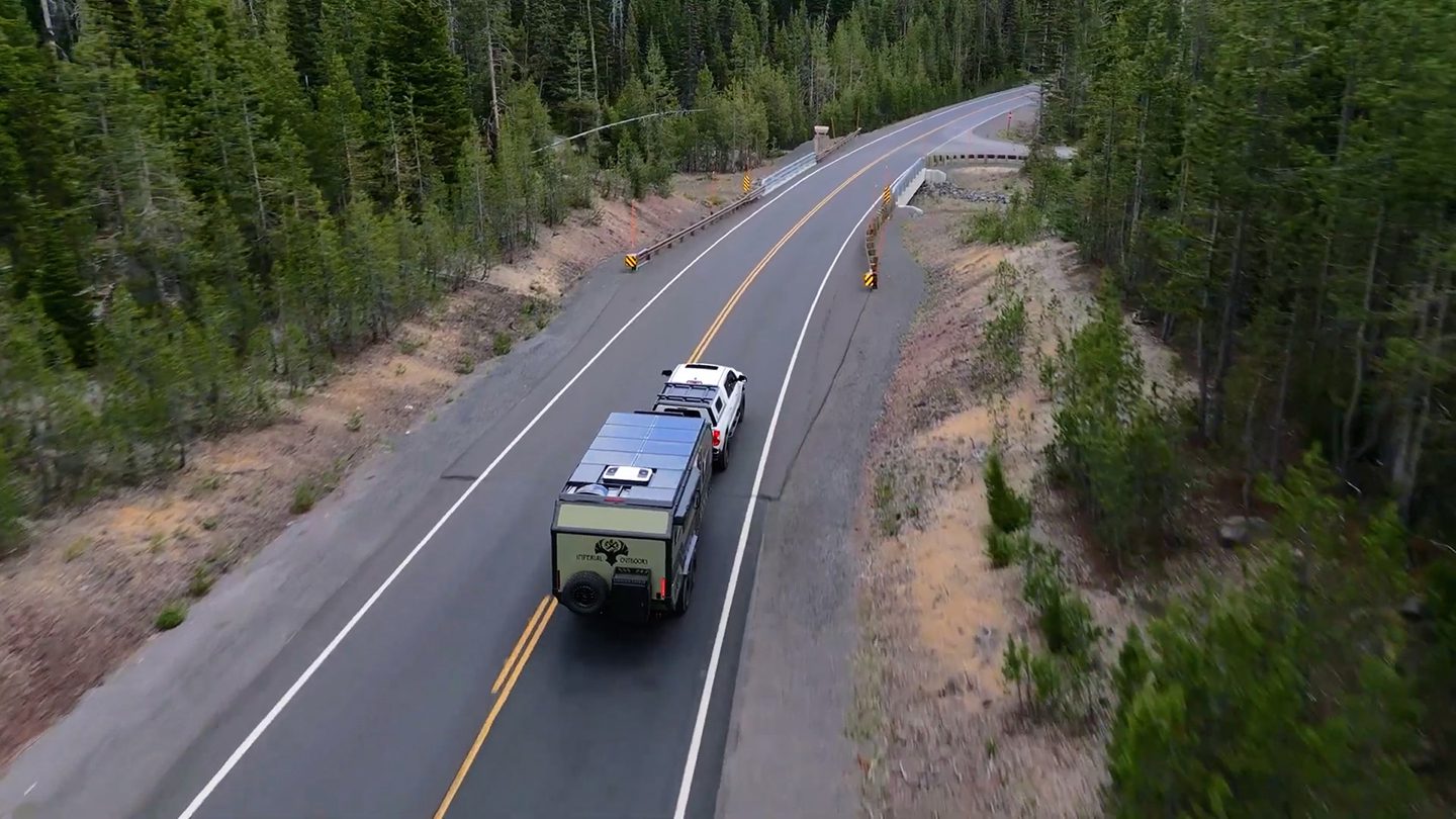 Imperial Outdoors Xplore Series X195 driving down a pine forest road.
