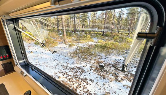 Dual pane thermal acrylic window that keep you warm in the Imperial Outdoors off grid camper in the winter forest.