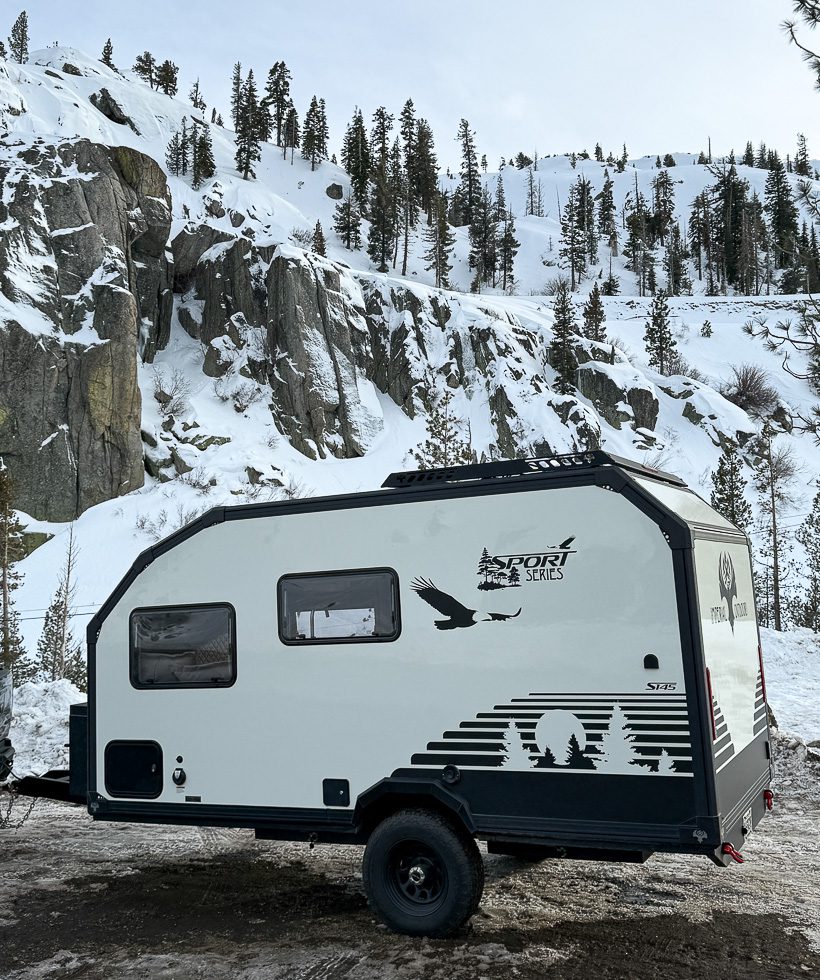 Imperial Outdoors Sport Series S145 camper traveling along a winter road in the mountains.