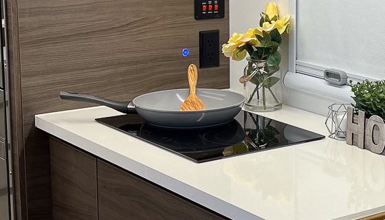 Imperial Outdoors X195 dual burner True Induction cooktop with frypan and spoon.